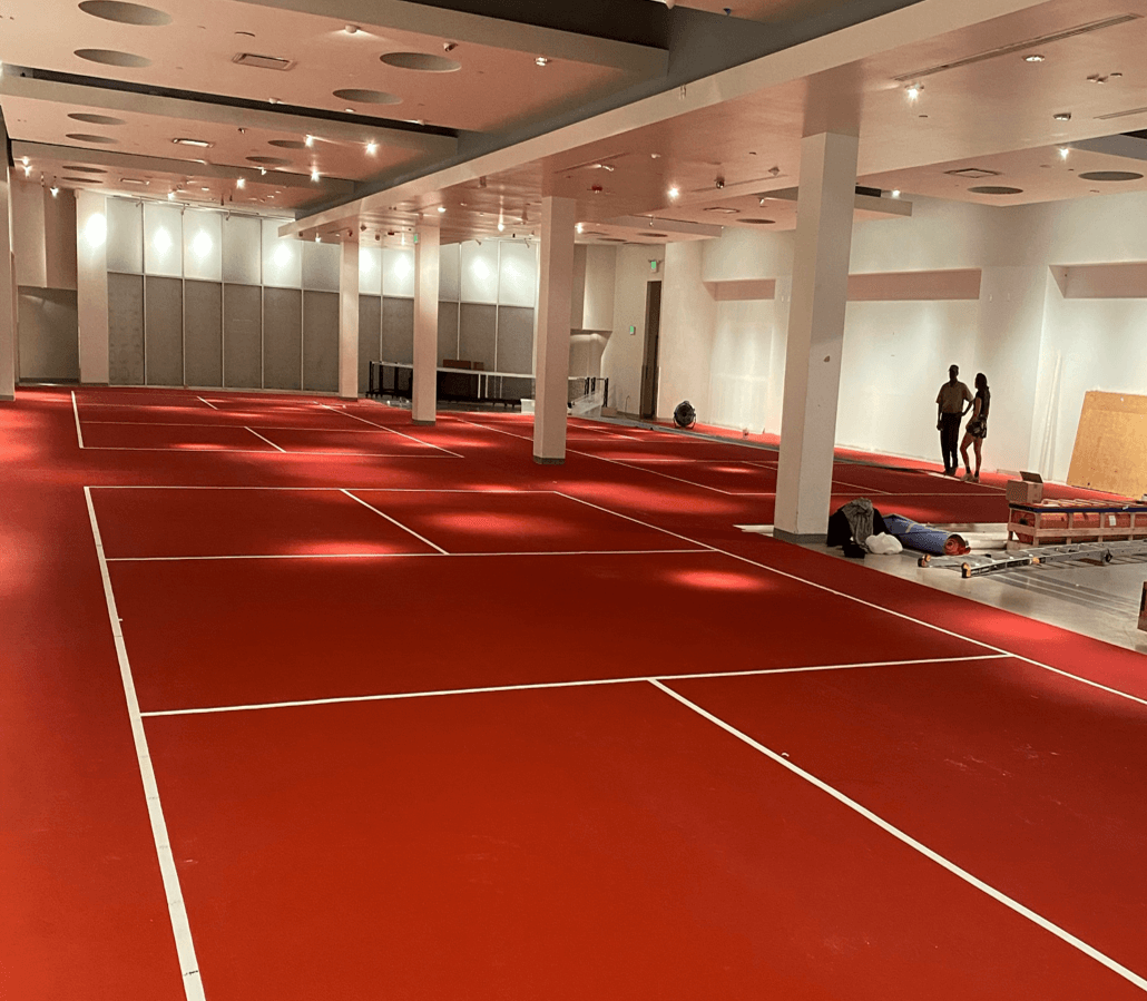 Rollout pickleball courts being installed across a commercial interior space